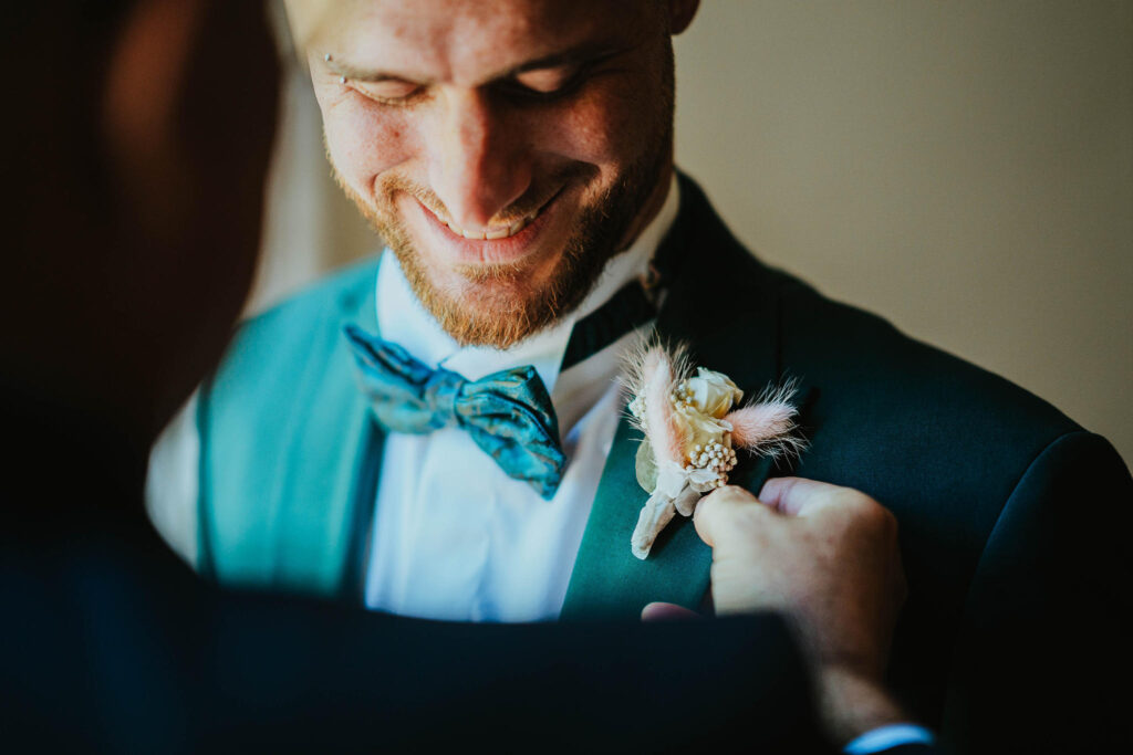 Sposo felice con bottoniera preparata per il matrimonio.